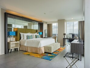 Une chambre d’hôtel moderne, dotée d’un grand lit, d’un bureau, d’une chaise et offrant une vue sur la ville.