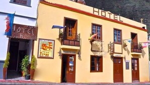 A hotel with a reception area, balconies, and a mountain backdrop. - Hotel Rural Villa Hermigua (Hermigua)