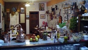 A kitchen with a bar area, featuring a ceiling fan, various kitchen utensils, and a fruit bowl on the counter. - Hotel Rural Villa Hermigua (Hermigua)