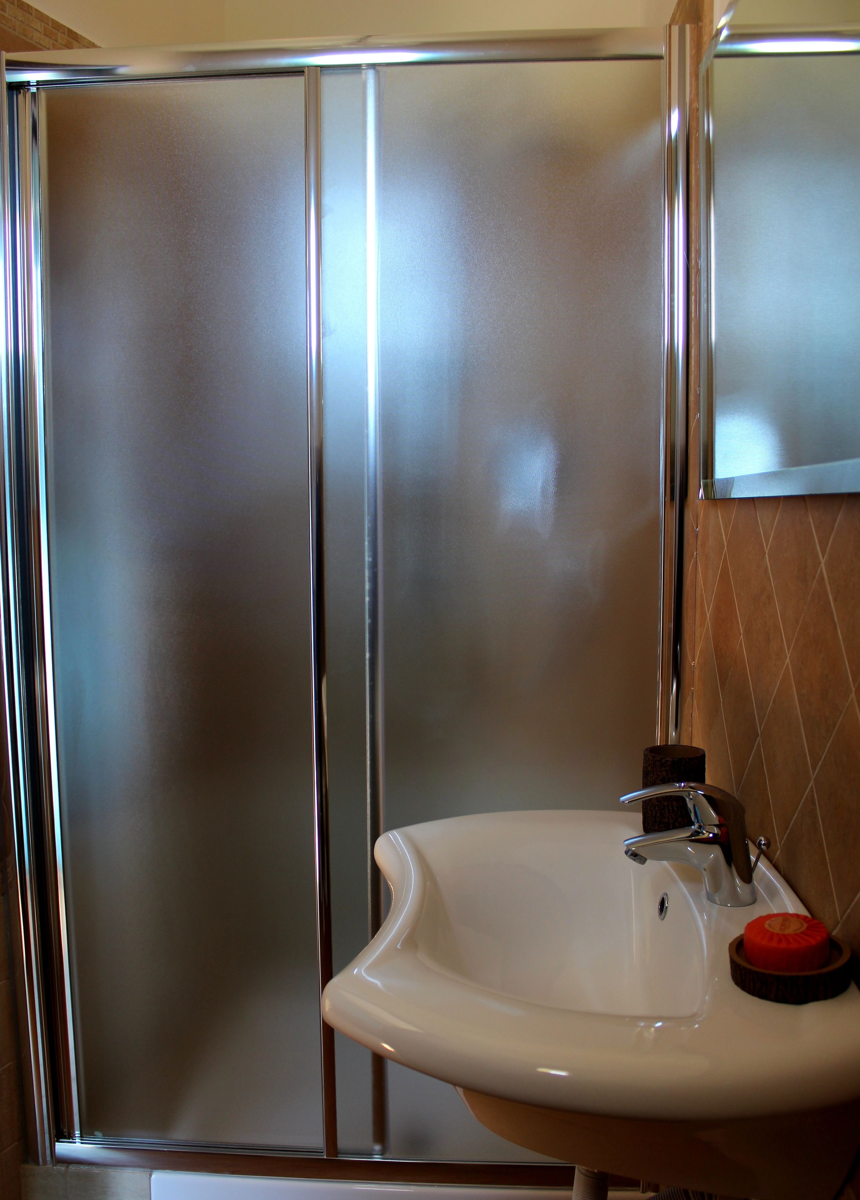 A bathroom with a shower enclosure and a sink.