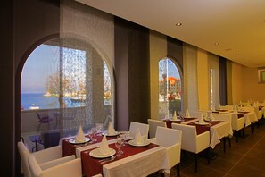 A restaurant with tables set for dining, large windows with views, and a modern interior design. - Hotel Lipa (Postira)