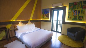 A bedroom with a bed, bedside table, lamp, and a chair. - Bharani Hostel (Bangkok)