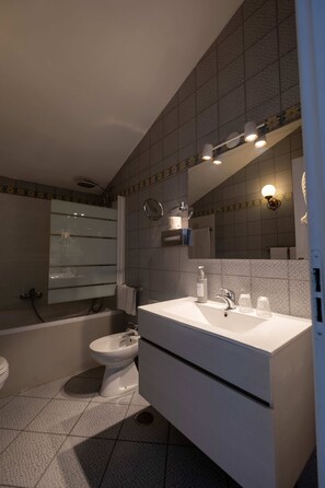Habitación doble superior, vistas al mar | Baño | Ducha y bañera combinadas y bañera profunda