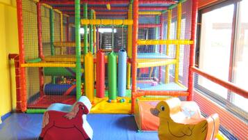 Children can play safely in this enclosed play area with a variety of play structures and soft surfaces.