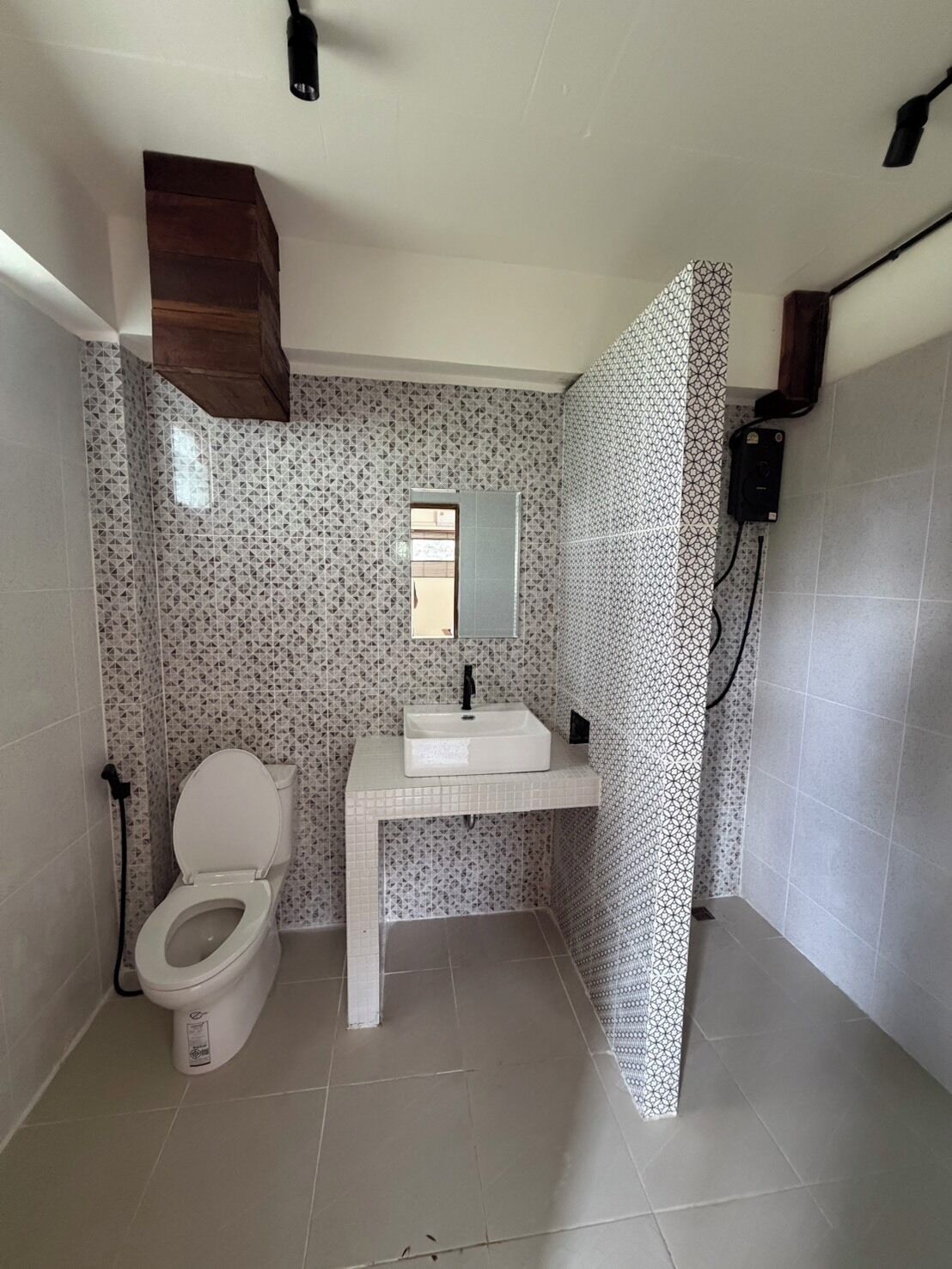 A bathroom with a toilet, sink, and patterned walls.