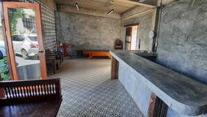 Una habitación con una barra alargada, un banco de madera y suelo de baldosas.