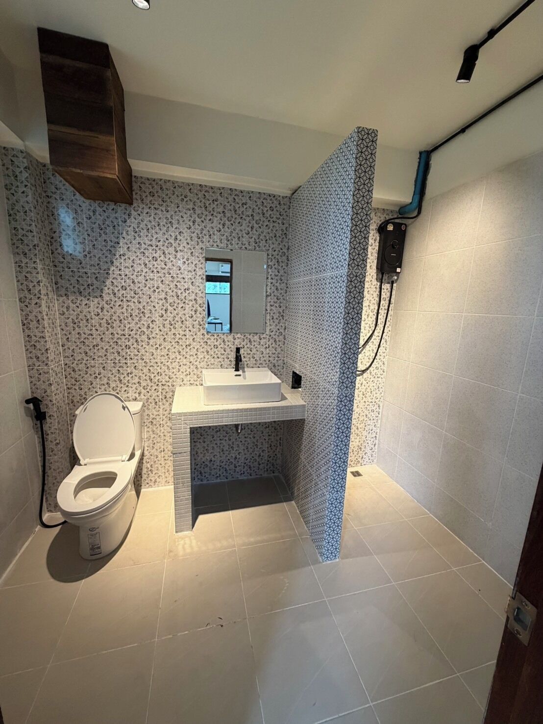 Un baño con inodoro, lavabo y zona de ducha.