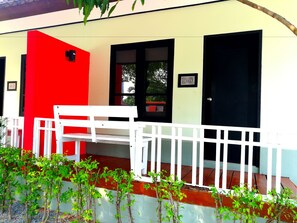 A building with a red and white exterior, a white bench, and a white fence. - Nice Resort Pattaya (Pattaya)