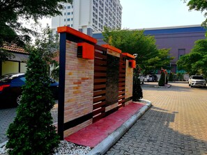 A modern building with a brick facade and a red and black entrance. - Nice Resort Pattaya (Pattaya)