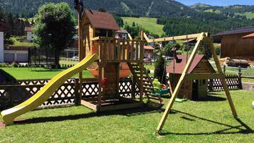 Children can play on the slide, climbing wall, and swing set in this well-maintained outdoor space.