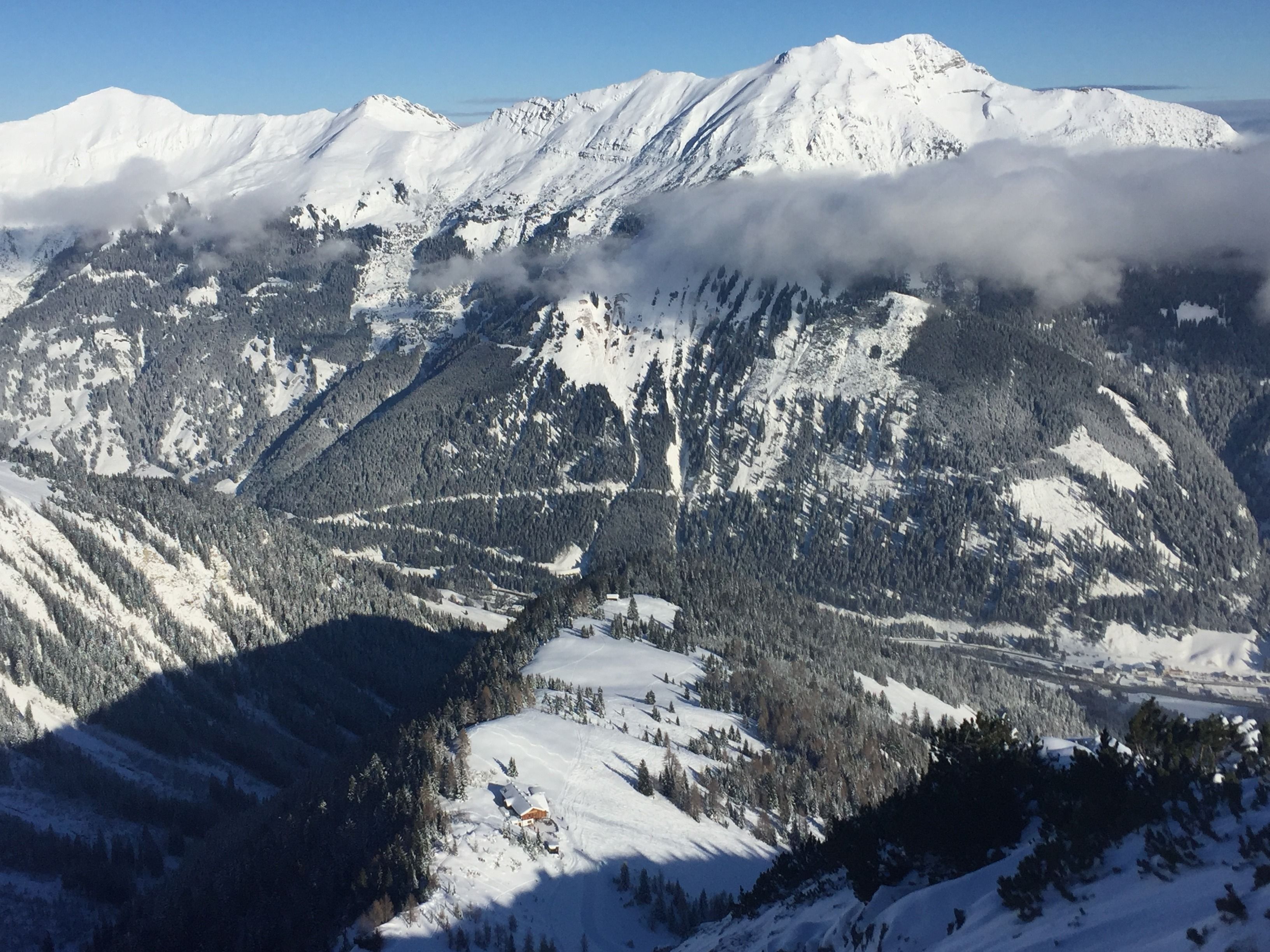 A snow-covered mountain landscape with a cabin in the foreground.