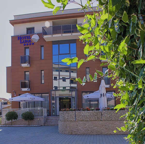 A hotel with a modern facade, a balcony, and outdoor seating. - Hotel Luna (Citluk)