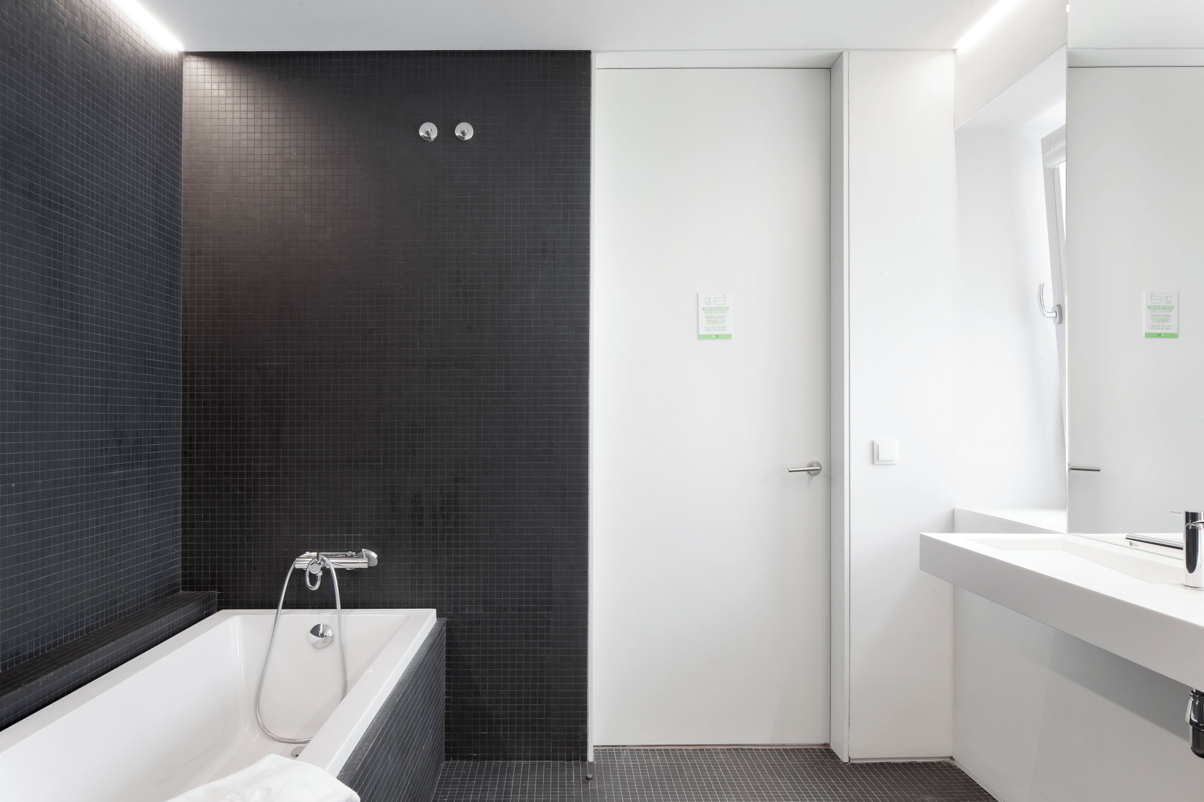 Un baño moderno con bañera, un lavamanos blanco y un espejo.