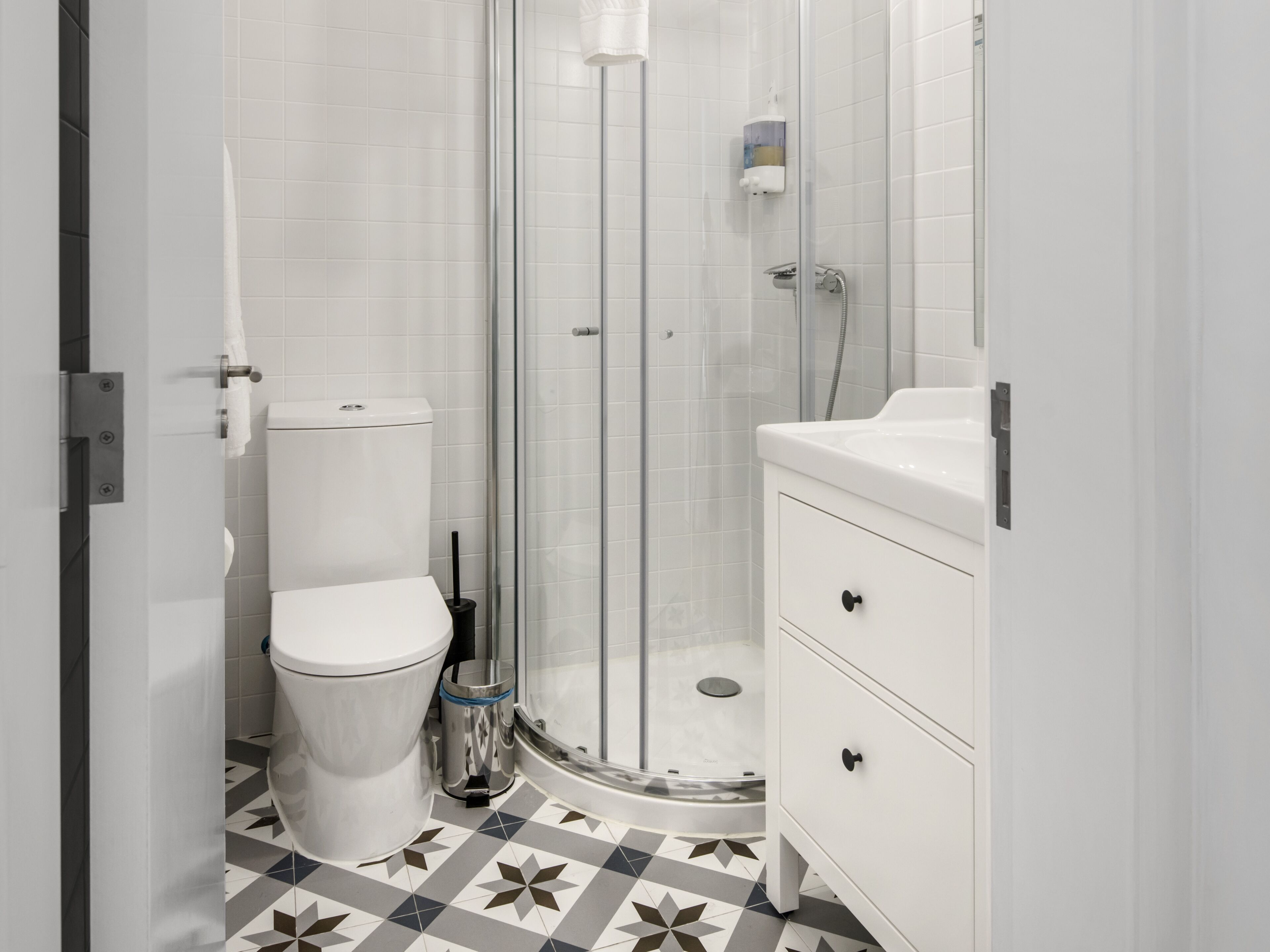 Ein Badezimmer mit Toilette, Duschkabine und Waschbecken mit Spiegel.