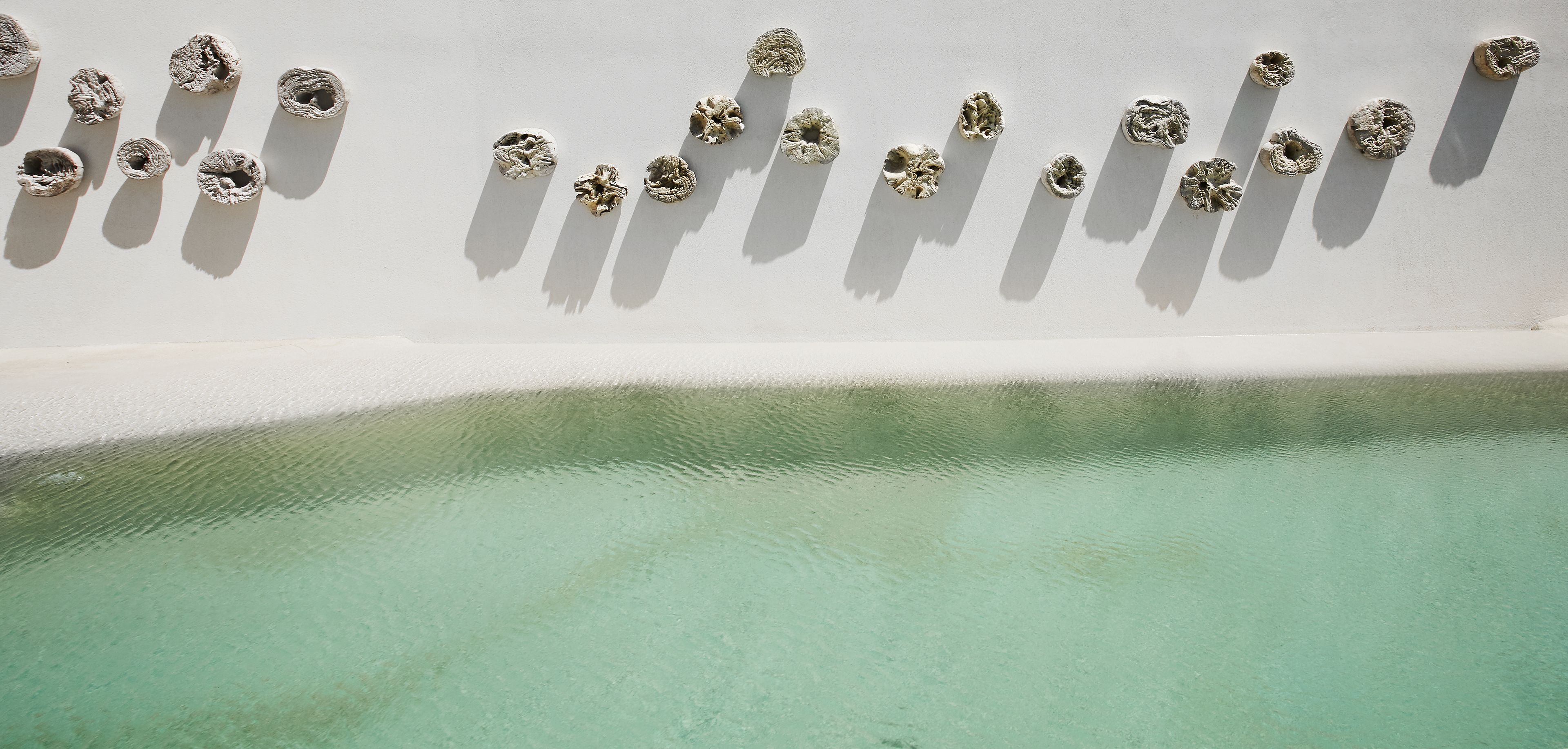 A white wall with circular objects arranged in a row.