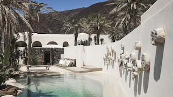 Una piscina al aire libre de temporada, sombrillas