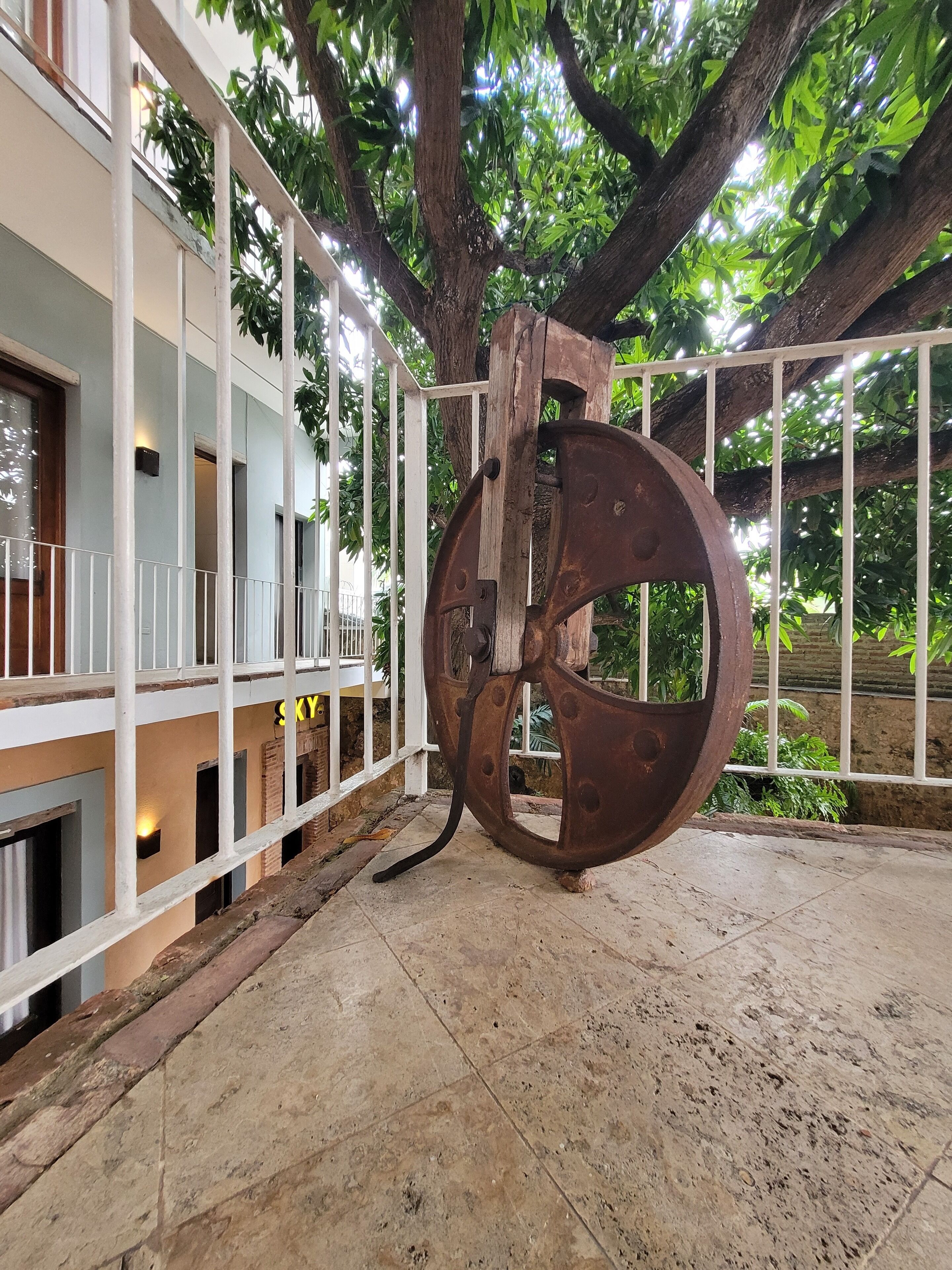 A large metal sculpture in an outdoor area with a building in the background.