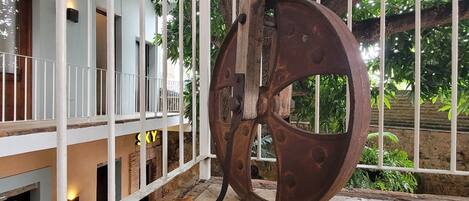 A large metal sculpture in an outdoor area with a building in the background.