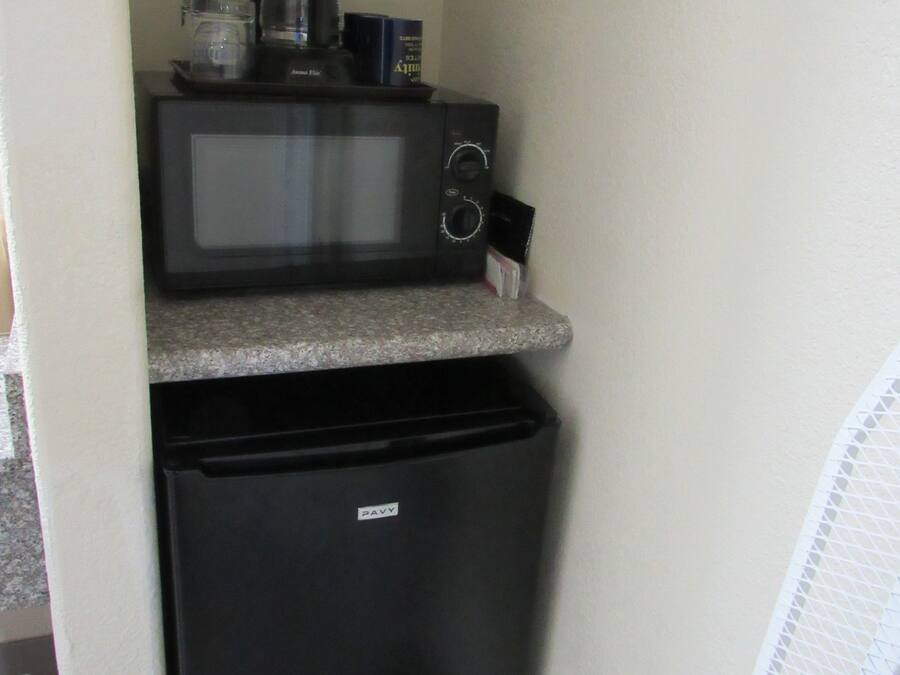 A compact kitchenette with a microwave and a small refrigerator.