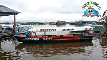 Una barca chiamata B/F Nativa con il numero di registrazione IQ-34106-BF ormeggiata in un porto fluviale.