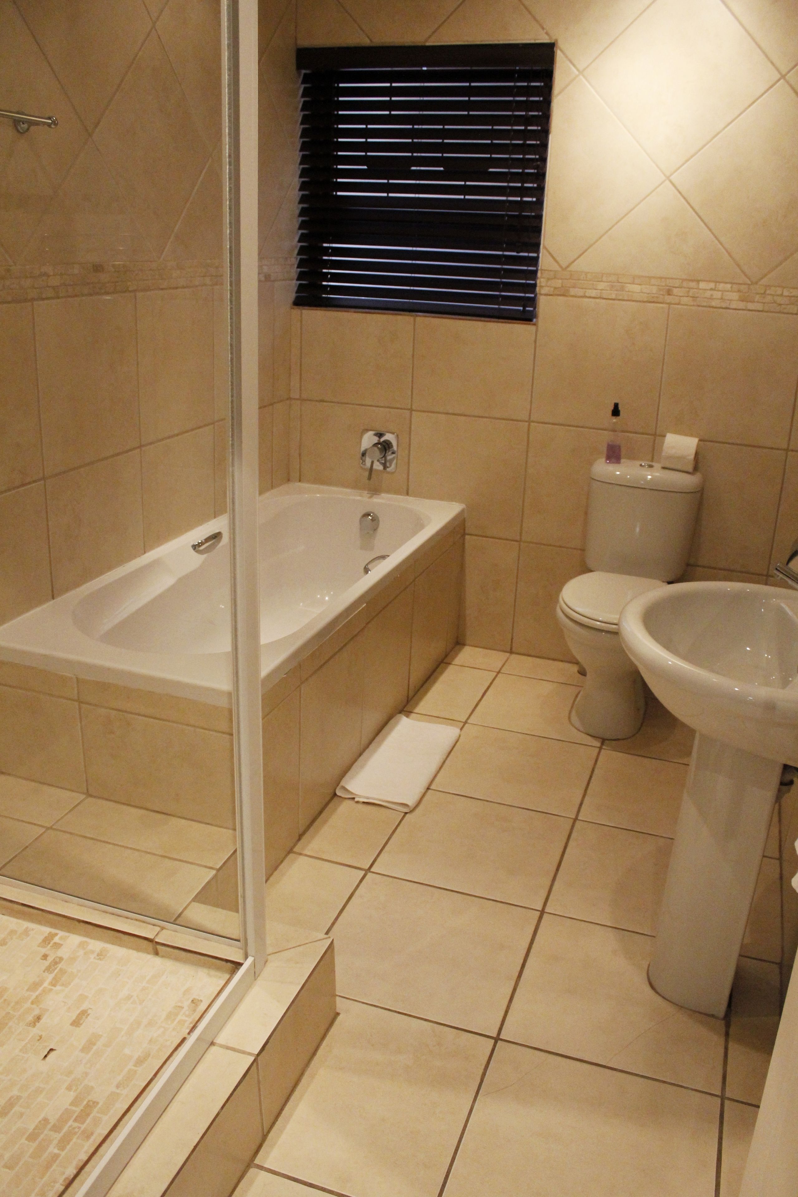 Een badkamer met een badkuip, toilet en wastafel.