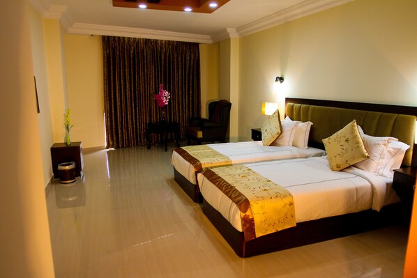 A hotel room with two beds, a desk, a chair, and a curtain. - Queen Plaza Hotel (Hebron)
