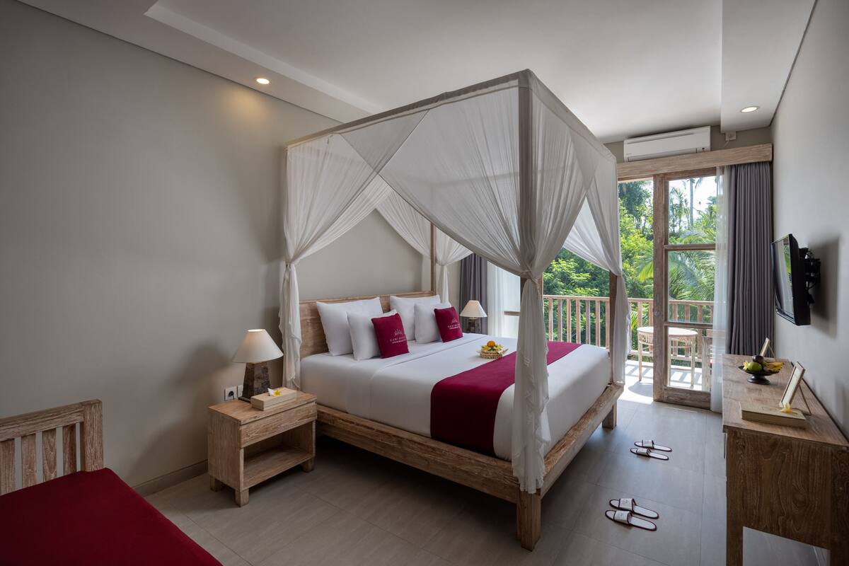 A bedroom with a four-poster bed, wooden nightstands, a bedside table, and a view of the outdoors.