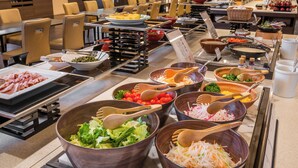 A buffet setup with various food items and utensils.