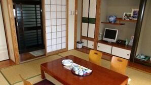 A traditional Japanese-style room with tatami flooring, a wooden dining table with a tray of tea, and shoji screens. - Hotel Big Marine Amami (Amami)
