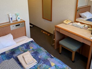 Una habitación de hotel con una cama, un escritorio, una silla, un teléfono y un espejo.
