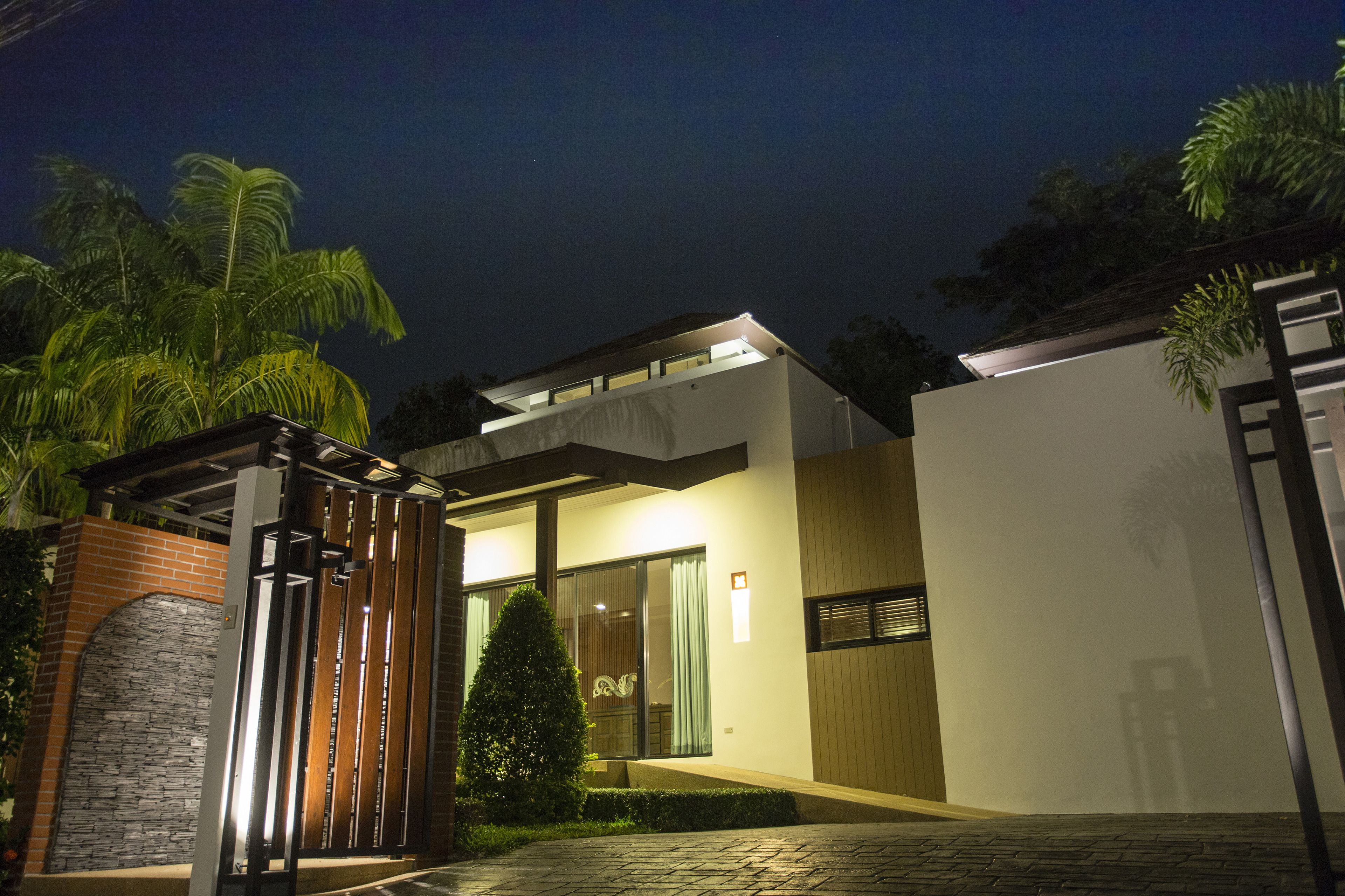 Ein modernes Haus mit Backsteineinfahrt, Glastür und einem hellen Innenraum.