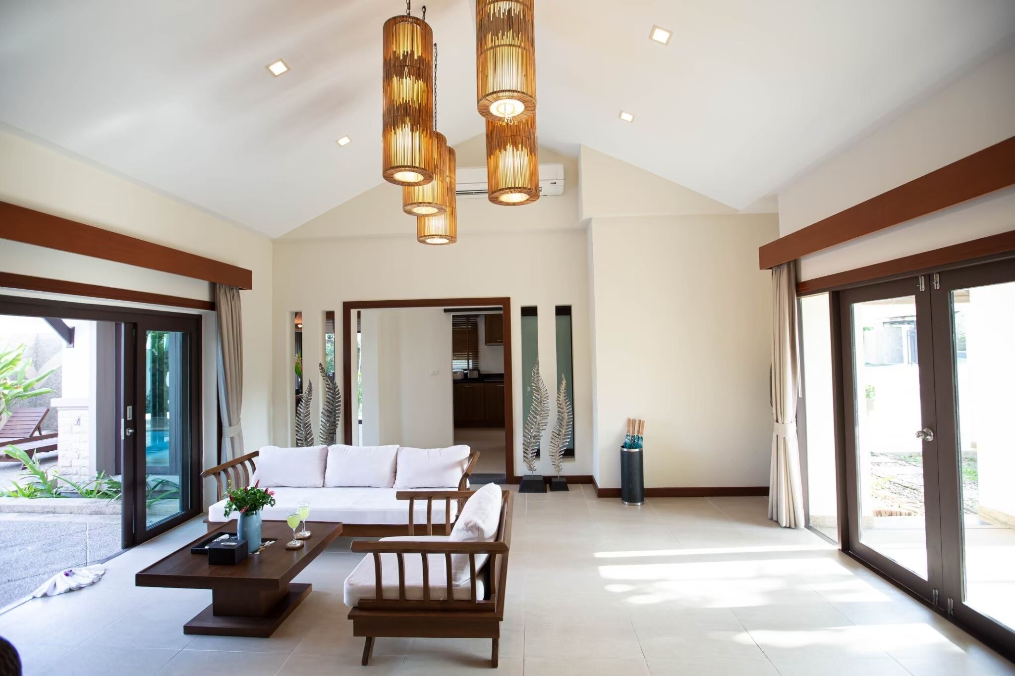 A spacious living area with a sofa, coffee table, and pendant lights.