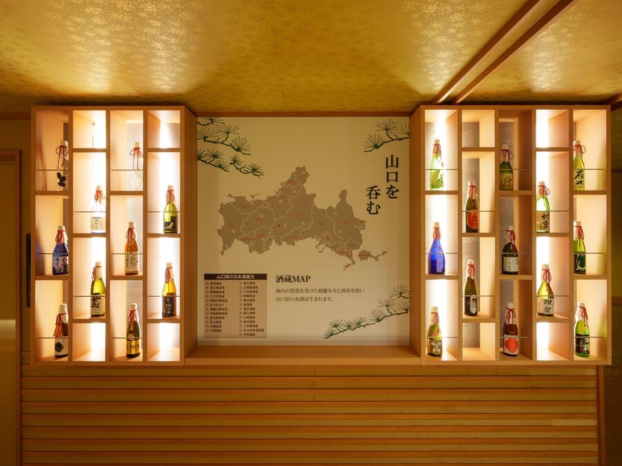 Une exposition de différentes bouteilles présentées sur des étagères en bois, avec une carte et du texte en arrière-plan.
