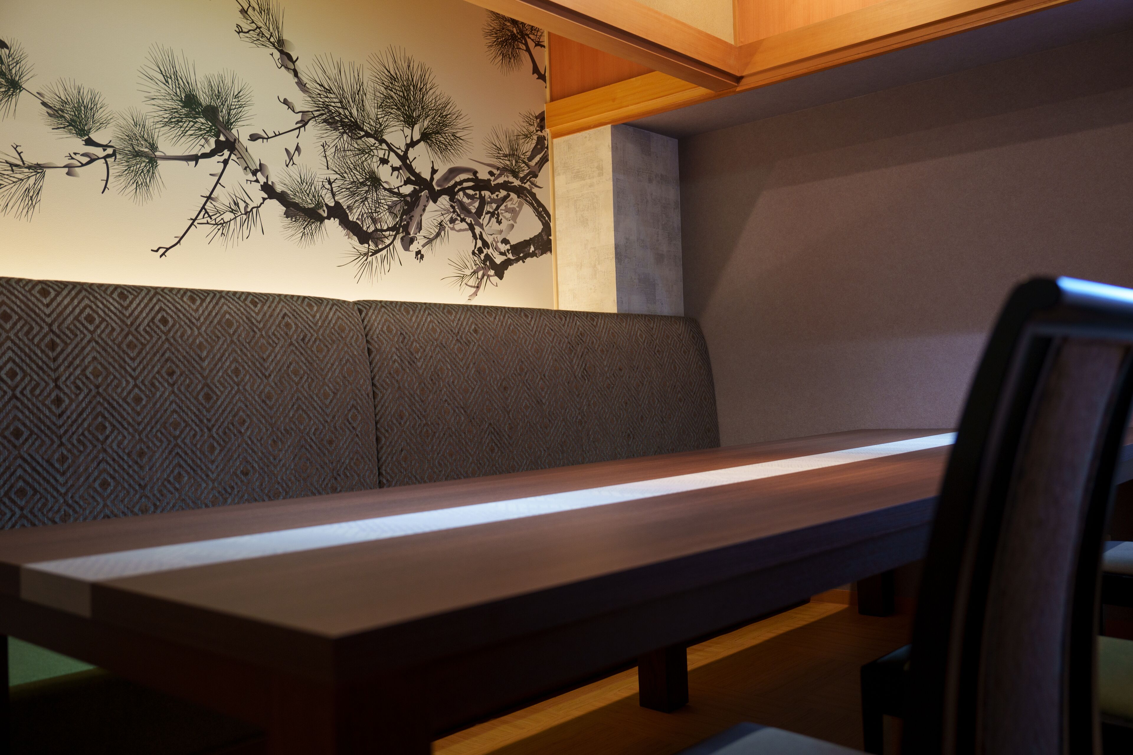 A seating area with a bench and a patterned wall.