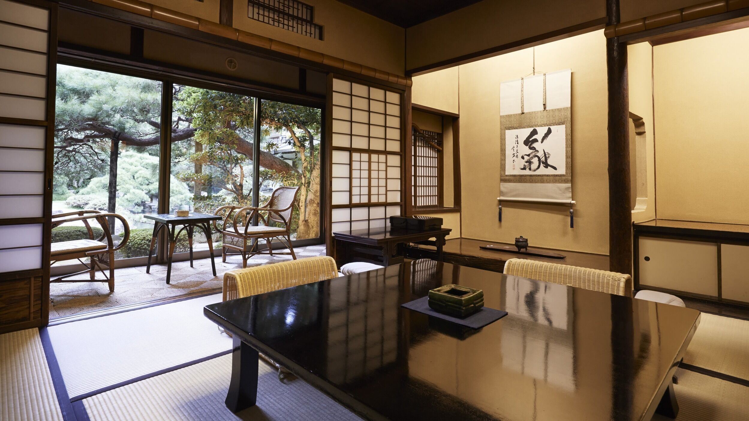 Ein traditioneller japanischer Raum mit Tatami-Boden, einem niedrigen Tisch und Schiebetüren.