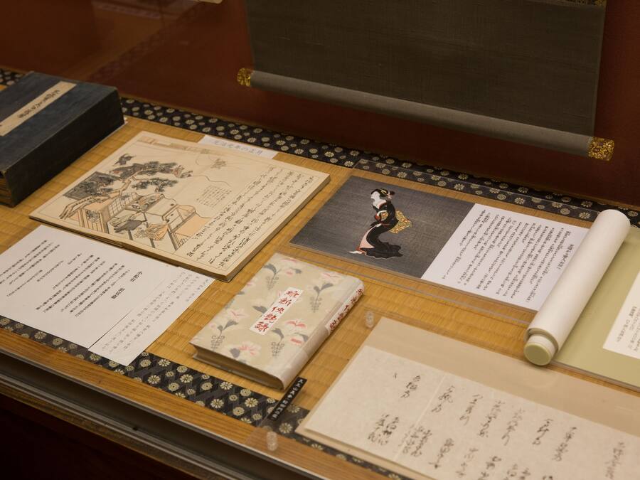 A display of traditional Japanese documents and books on a wooden table.