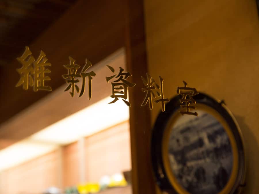 A sign with Chinese characters, a circular mirror, and a blurred background.