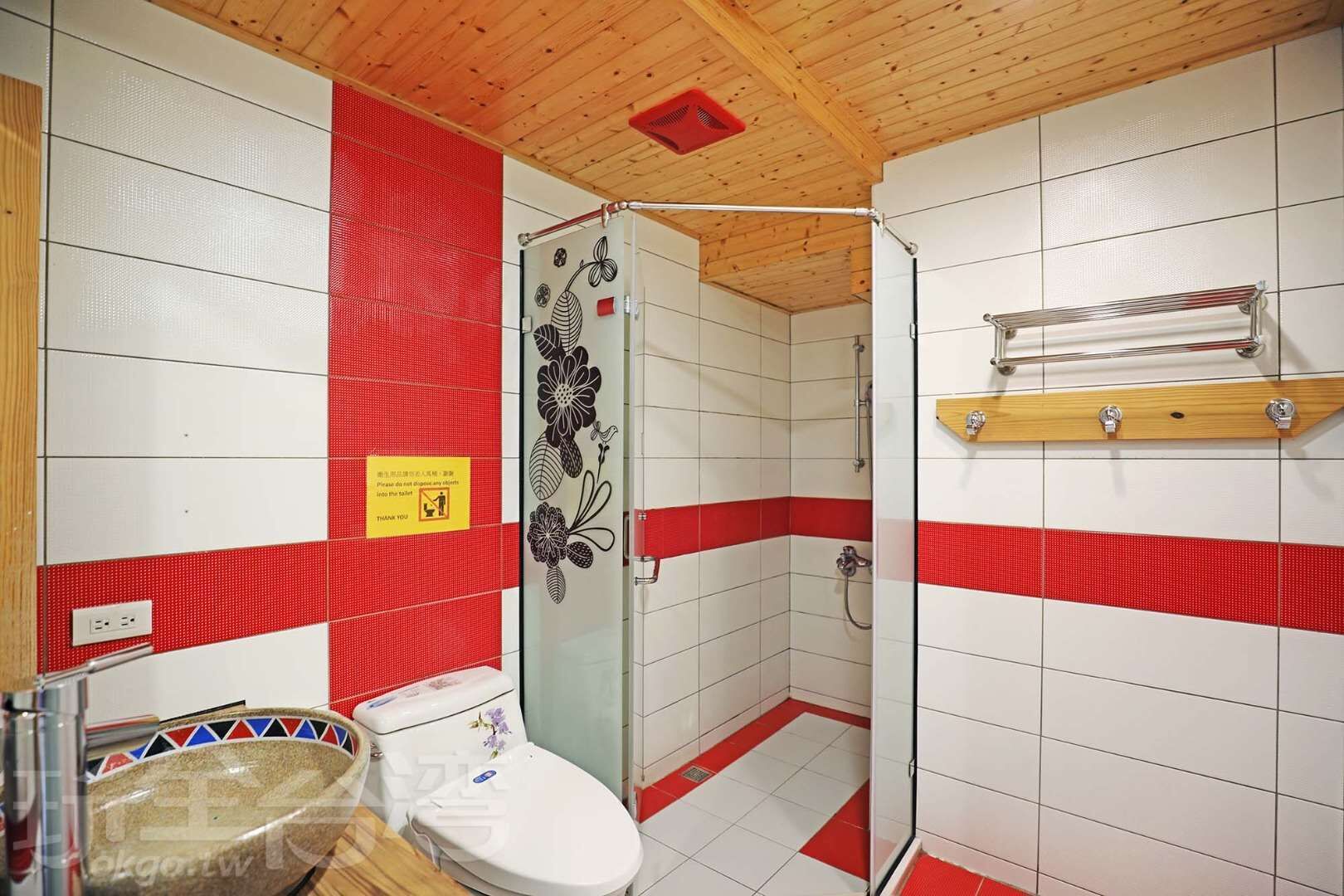 Baño con ducha, inodoro y toallero.