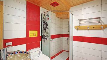 A bathroom with a shower, toilet, and a towel rack.