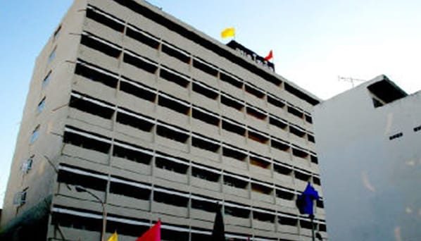 A multi-story building with a grid-like facade, featuring numerous windows and balconies.