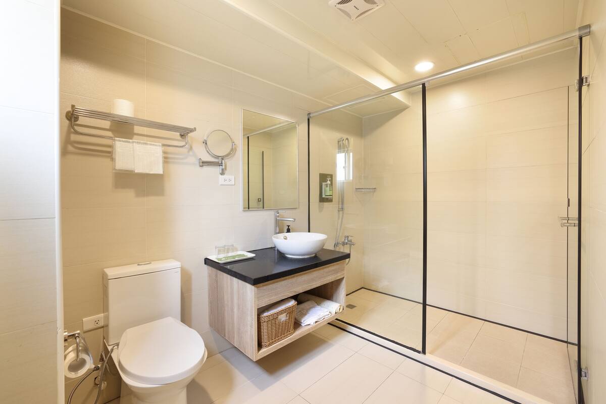 Ein modernes Badezimmer mit Toilette, Waschbecken und Duschkabine aus Glas.