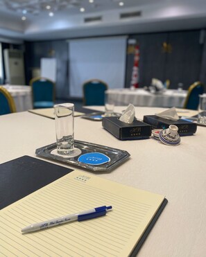 A conference table with a notepad, pen, tissue box, and a decorative item. - Le Belvedere (Tunis)