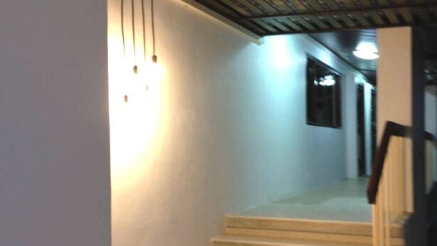 Una escalera que conduce a una plataforma con una lámpara colgante.