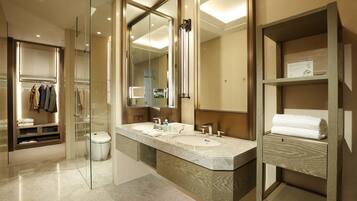 A modern bathroom with two sinks, a glass shower enclosure, and a vanity with a mirror.