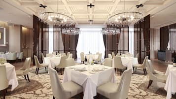 Ein stilvoller Speisesaal mit runden Tischen, weißen Tischdecken und eleganten Stühlen.