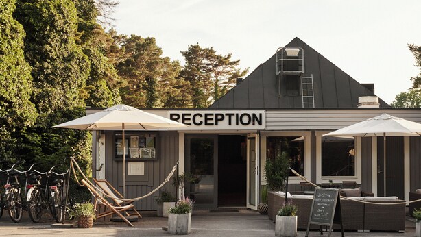 A reception area with a sign, outdoor seating, and bicycles. - Visby Gustavsvik (Visby)