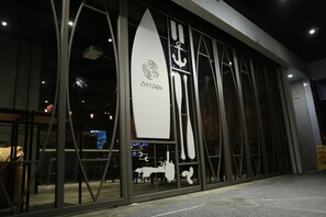 A building facade with a large glass window displaying a surfboard logo and the word "OXYGEN". - Taipei Oxygen Hostel Ximending (Taipei)