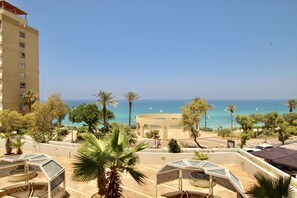 A coastal hotel with a view of the sea, palm trees, and a circular building in the center. - Royal Apartments (Netanya)