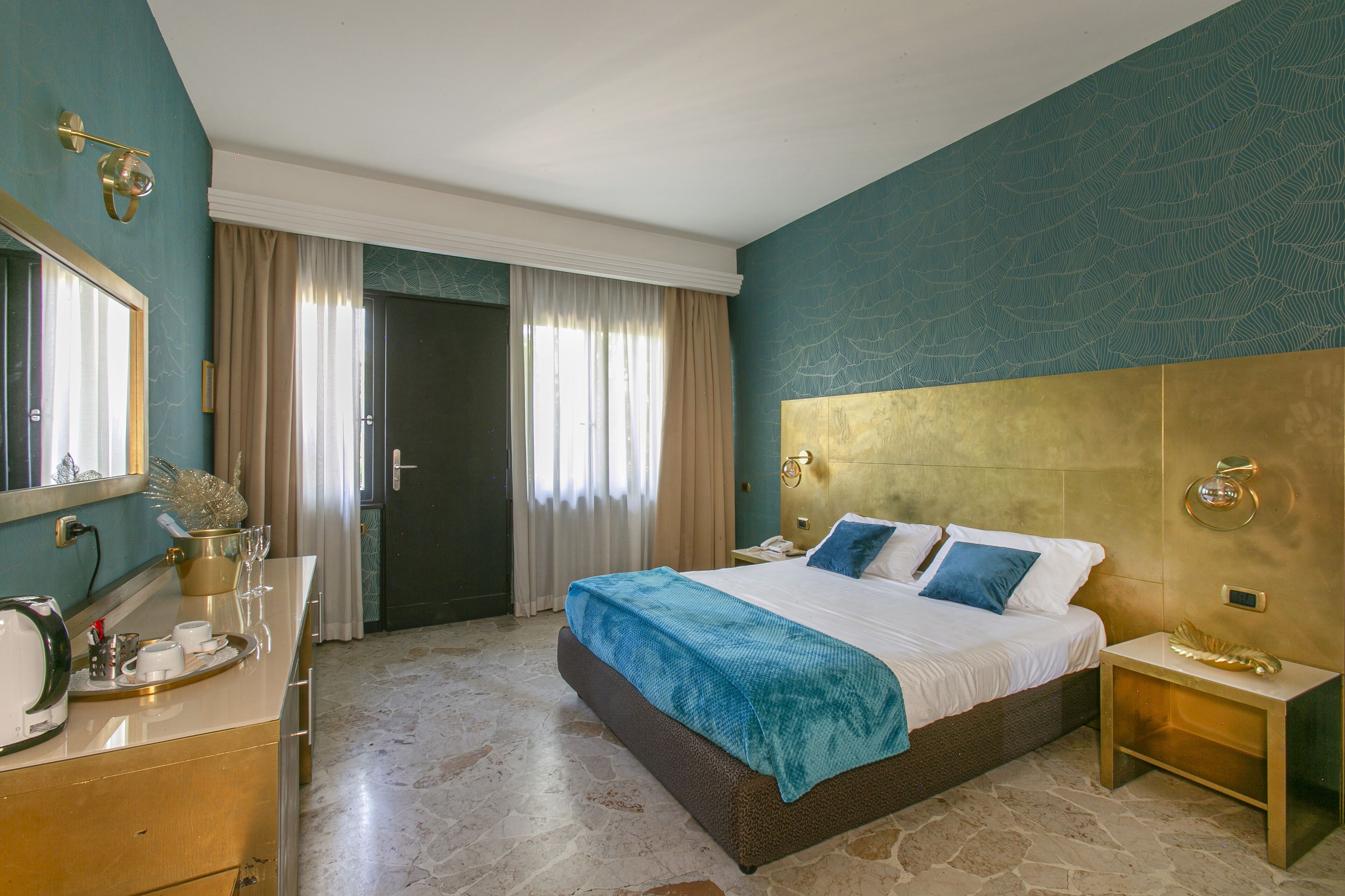 Una habitación de hotel con cama, mesita de noche y espejo.