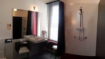Ein Badezimmer mit Waschbecken, Spiegel und Dusche.